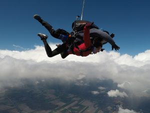 Un duo instructeur de parachute et sa passagère tandem passent au coeur des nuages, durant la chute libre.