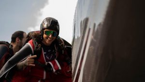 Une parachutiste sourie à la caméra juste avant d’embarquer dans l’avion. 