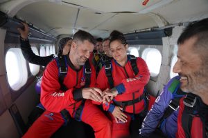 Un couple échange leurs alliances durant leur mariage célébré dans un avion de parachute, chez Parachute Voltige. 